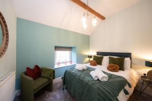 1 dormitorio con 1 cama grande y toallas. en Mycock Cottage en Buxton