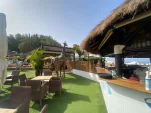 een giraf die voor een restaurant staat bij Modern Duplex apartment near swimming pool in Mogán