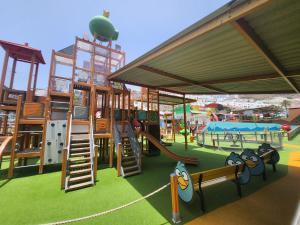 een speeltuin met een glijbaan en een speeltuin bij Modern Duplex apartment near swimming pool in Mogán