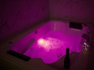 - une baignoire pourpre avec 2 verres à vin dans l'établissement Le Moment Bien-Être - Appartement avec SPA privatif, à Saint-Omer