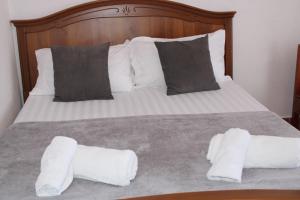a bed with two pillows and two towels on it at Deni Family Apartament in Tirana