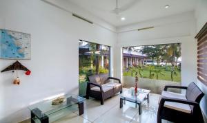 a living room with two chairs and a table at Treebo Trend Majestic Retreat in Varkala