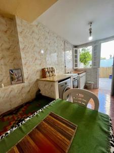 uma cozinha com uma mesa, um fogão e um balcão em La maisonnette em Sidi Bou Said