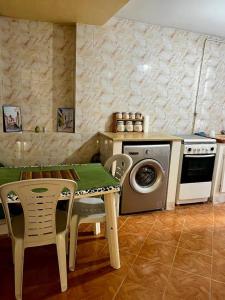 uma cozinha com uma mesa e uma máquina de lavar roupa em La maisonnette em Sidi Bou Said