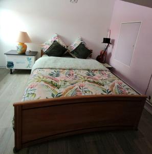 1 dormitorio con 1 cama grande con colcha de flores en Charmant petit Studio en duplex, en Le Fenouiller