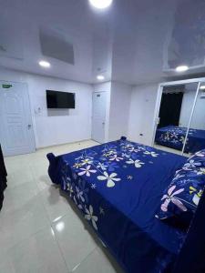 Un dormitorio con una cama azul con flores. en Alojamiento paulino, en Santiago de los Caballeros