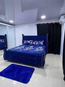 a blue bed in a room with blue rugs at Alojamiento paulino in Santiago de los Caballeros