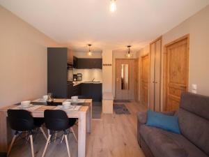 ein Wohnzimmer und eine Küche mit einem Tisch und einer Couch in der Unterkunft Charmant T2 avec parking à Valmorel - FR-1-291-867 in Valmorel