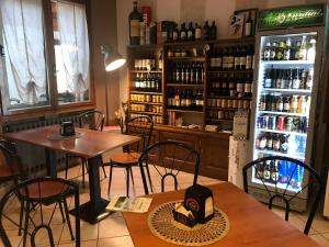 a restaurant with a table and chairs and a refrigerator at La Buca delle Fate in Pievepelago