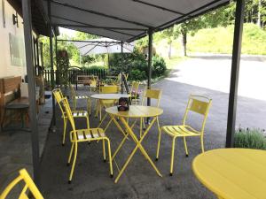 un groupe de tables et de chaises sous une tente dans l'établissement La Buca delle Fate, à Pievepelago