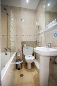 La salle de bains est pourvue de toilettes, d'un lavabo et d'une douche. dans l'établissement Pensión Carrera, à Madrid
