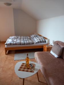 um quarto com uma cama e uma mesa com uma garrafa em Penzion Bernardýn em Bořetice