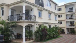 a large white building with palm trees in front of it at Paradise Hill in Grand Baie