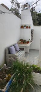 a patio with a bench and a table with plants at Il Mirto Blu in Porto Cesareo