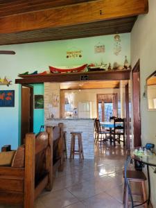 a kitchen and dining room with a bar with chairs at Ilhabela Casa Família Feliz in Ilhabela