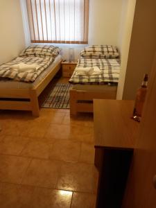 um quarto com 2 camas e piso em azulejo em Penzion Bernardýn em Bořetice