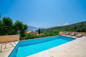 a swimming pool in a villa with mountains in the background at Villa Apollo up to 8px, private pool in Fiskardho