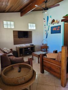 a living room filled with furniture and a flat screen tv at Ilhabela Casa Família Feliz in Ilhabela