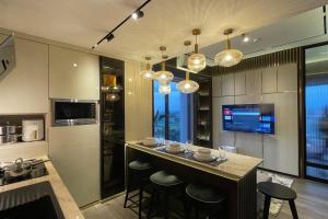 a kitchen with a bar with stools and a tv at Stunning 2 Bedroom Apartment in Yogyakarta