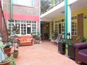 een patio met meubilair en planten in een gebouw bij EUCALYPTUS POTOSI in Potosí