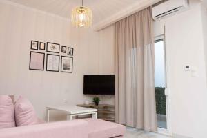 a living room with a pink couch and a tv at Olga's Luxury Apartment-Thessaloniki Centre in Thessaloniki