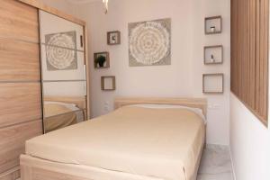 um quarto branco com uma cama e um espelho em Olga's Luxury Apartment-Thessaloniki Centre em Tessalônica