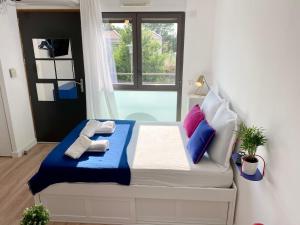 1 dormitorio con 1 cama con almohadas azules y blancas en Ma place au sud 1.08, en Éguilles