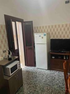 een keuken met een witte koelkast en een magnetron bij Girasole in Trepuzzi