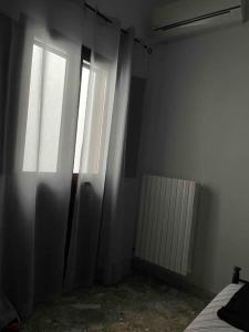 een lege kamer met een raam en een radiator bij Girasole in Trepuzzi