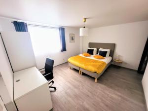 1 dormitorio con cama, escritorio y ventana en Calm and modern apartment, en Eischen