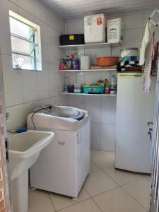 a small kitchen with a sink and a refrigerator at Ilhabela Casa Família Feliz in Ilhabela