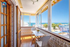 a balcony with a table and chairs and the ocean at Apartamentos Hibiscus Casa Azahar in Alcossebre