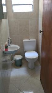 a bathroom with a toilet and a sink at Ilhabela Casa Família Feliz in Ilhabela