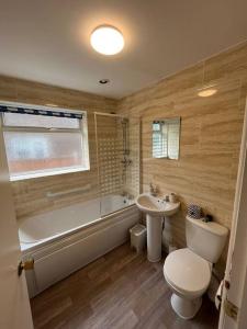 a bathroom with a tub and a toilet and a sink at Bungalow in the Peak in Glossop