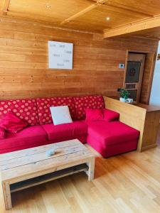 a living room with a red couch and a table at Haus Jomeity in Sillian