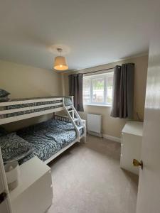 a bedroom with two bunk beds and a window at Bungalow in the Peak in Glossop