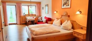 a bedroom with two beds and a table in it at Pension Berghof in Brannenburg