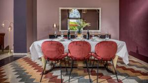 a dining room with a table with red chairs and a mirror at VILLA SUMAC 6, Emma Villas in Sortino