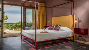 a bedroom with a canopy bed in a room with a window at VILLA SUMAC 6, Emma Villas in Sortino
