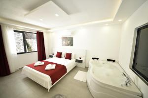 a white bedroom with a bed and a bath tub at Mayda Suit Aparts in Kas