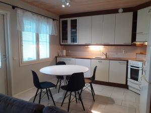 a kitchen with a table and chairs in a kitchen at Apartment Vuokatin Taika 2 - Loppusiivous sisältyy hintaan in Vuokatti
