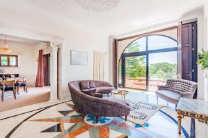 un soggiorno pieno di mobili e una grande finestra di Estoril Royal Atlantic Villa with Ocean View a Estoril