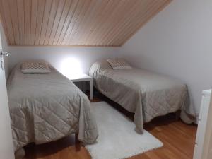- une chambre avec deux lits et une table avec une lampe dans l'établissement Apartment Vuokatin Taika 2, à Vuokatti