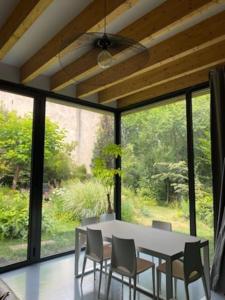 a dining room with a white table and chairs at L’atelier d’Alain in Maxéville