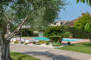 a swimming pool in a yard with a tree at Casa dei Sogni - Exclusive Suite in Villa in Lido di Ostia