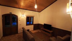 a living room with a couch and a television at Familia Sequeira in São Bartolomeu de Messines