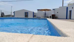 a swimming pool with blue water in front of a building at Familia Sequeira in São Bartolomeu de Messines