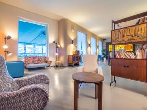 a living room with chairs and a table and a book shelf at Hotel Il Nido in Tellaro