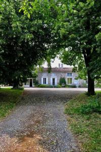 ein großes weißes Haus mit Bäumen davor in der Unterkunft La Saintonge in Saint-Sulpice-dʼArnoult