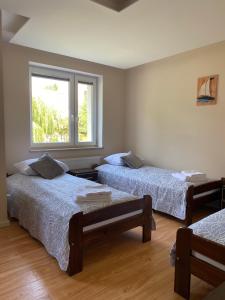 a room with two beds and a window at Dolores in Giżycko